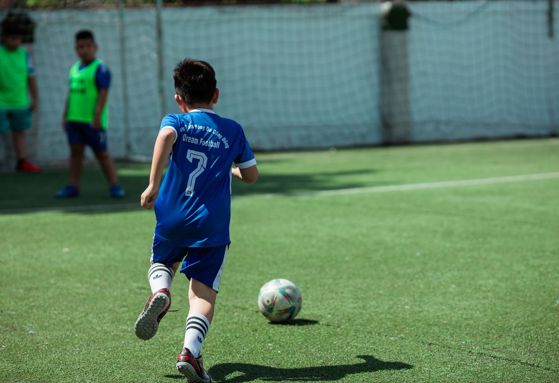グラウンドでサッカーをする子どもたち